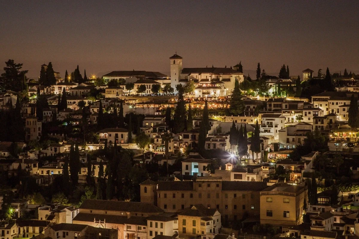 The Alhambra walls and towers lit by evening light seen from across the valley, Granada