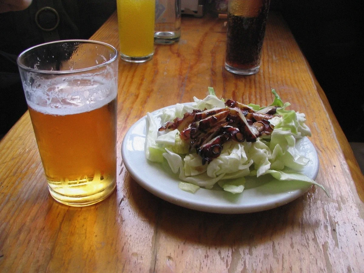 A plate of tapas with a drink at a Granada bar, Spain
